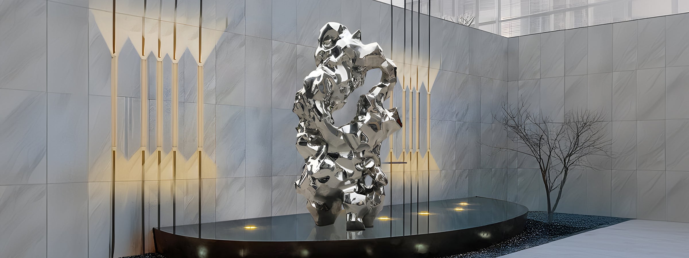 A large abstract metallic sculpture stands on a round platform in a modern, minimalist room with marble walls and vertical light fixtures. A small, bare tree is visible in the background.