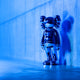 Iconify blue chrome sculpture standing against concrete walls, a luxury contemporary art piece.