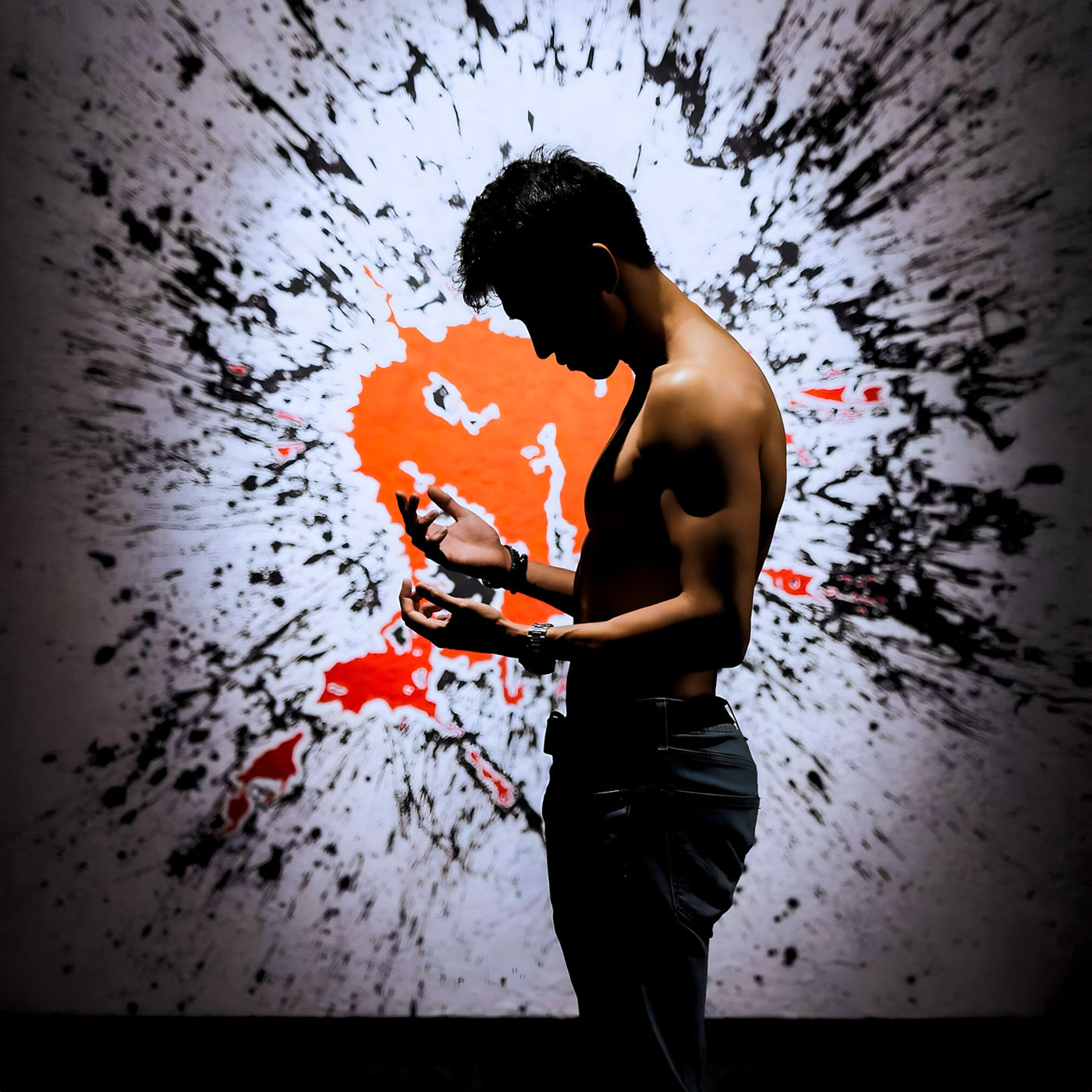 A shirtless person stands in profile, facing slight left, against an abstract black and red splatter art background. Their head is bowed as they look at their hands, creating a dramatic silhouette effect.