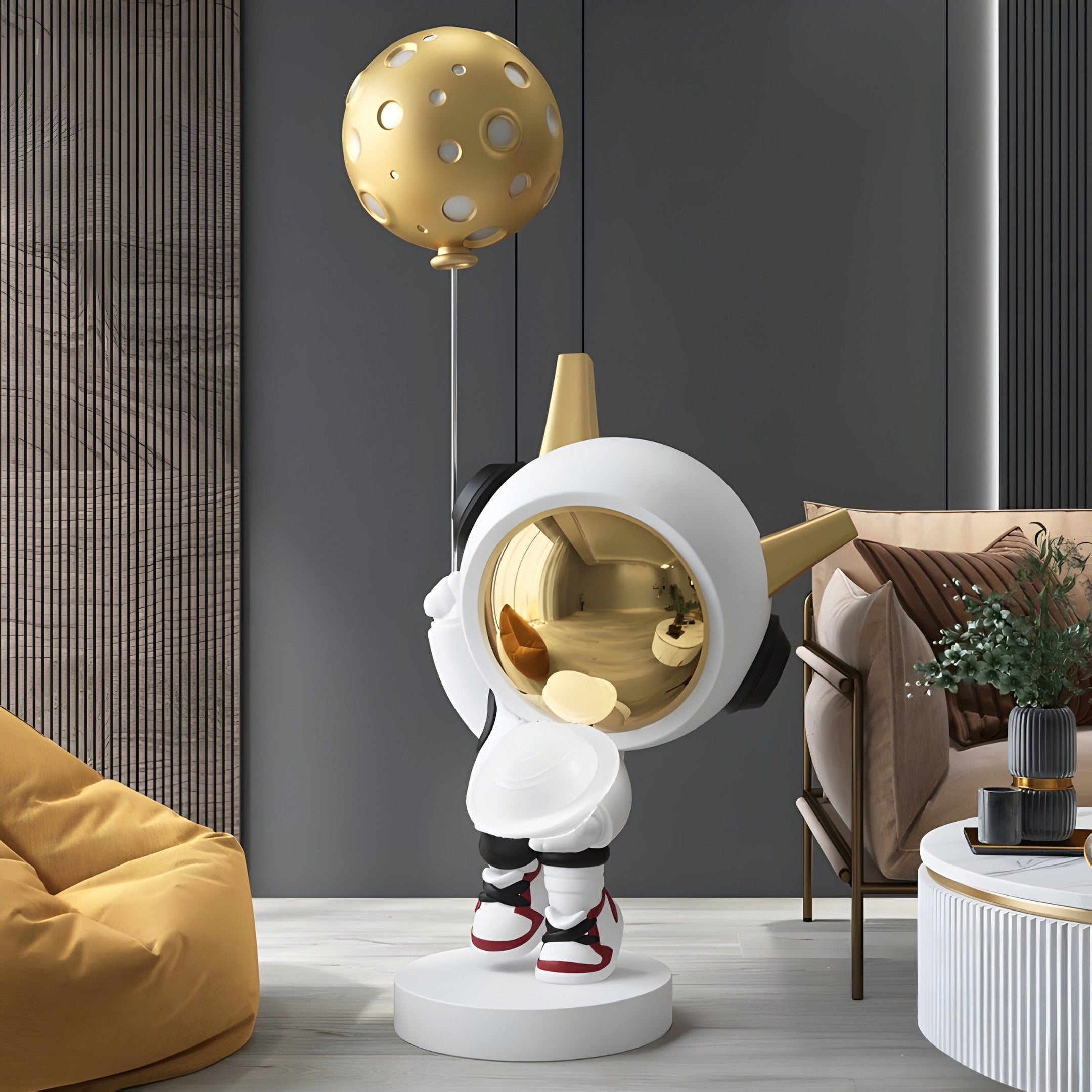 The Nova White Astronaut DJ Moon Balloon Sculpture - 100cm by Giant Sculptures features a sleek white suit with black and red shoes, a reflective gold visor, and clutching a DJ Moon Balloon, set against interplanetary charm with contemporary furniture and decor.