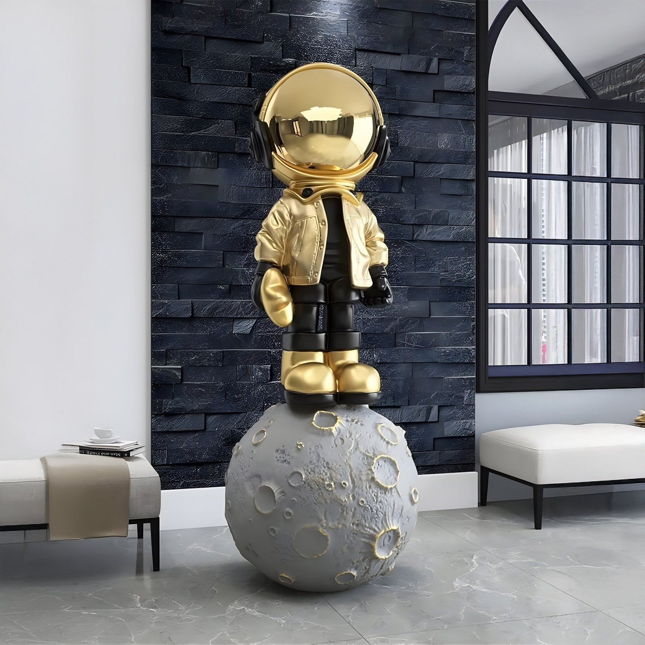 The Celestial Gold Astronaut Beats On Moon Sculpture by Giant Sculptures (140cm) graces a modern room with a dark textured wall, flanked by a large arched window on the right and a low bench with a cup on the left, creating an enchanting cosmic décor.