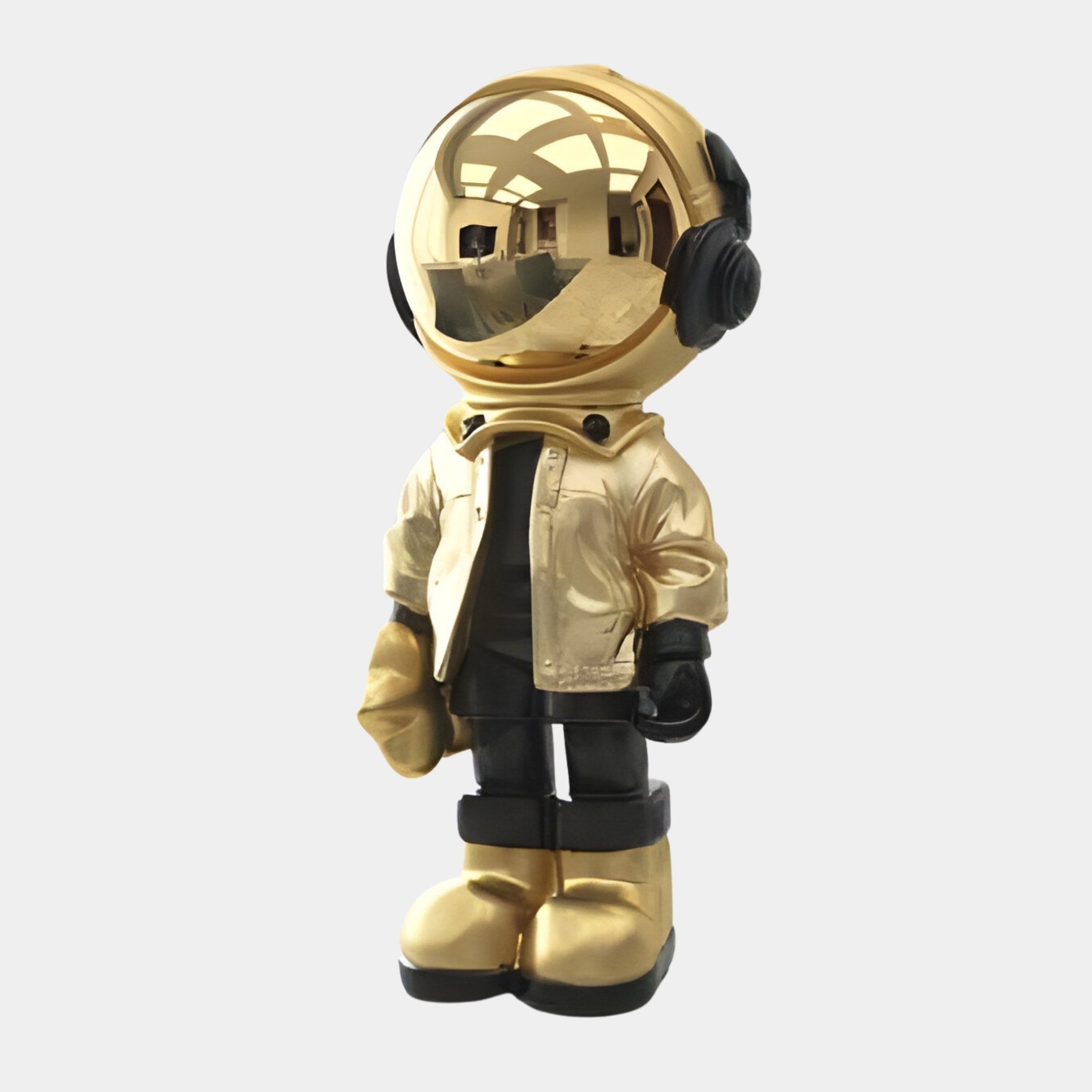 The Celestial Gold Astronaut Beats Figure by Giant Sculptures stands upright at 36cm, featuring headphones, a jacket, gloves, and a reflective visor. Its gold and black blend highlights its futuristic design, perfect for space-inspired décor.