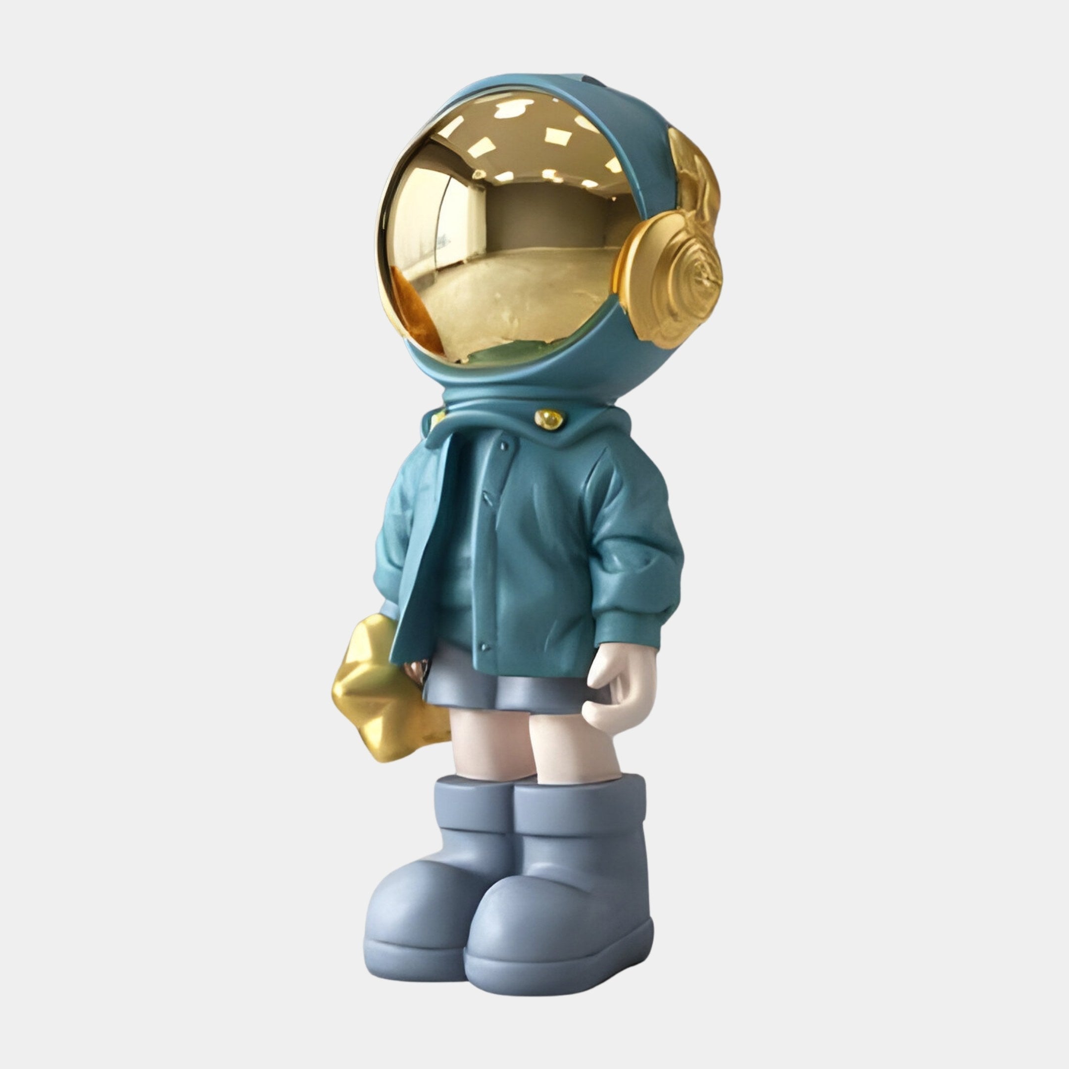 The Galactic Blue Astronaut Beats Sculpture by Giant Sculptures measures 70cm and showcases a small figure in a teal jacket, gold helmet, blue boots, and holding a gold star in its left hand. The reflective helmet adds charm to this space-inspired piece against a plain white background.