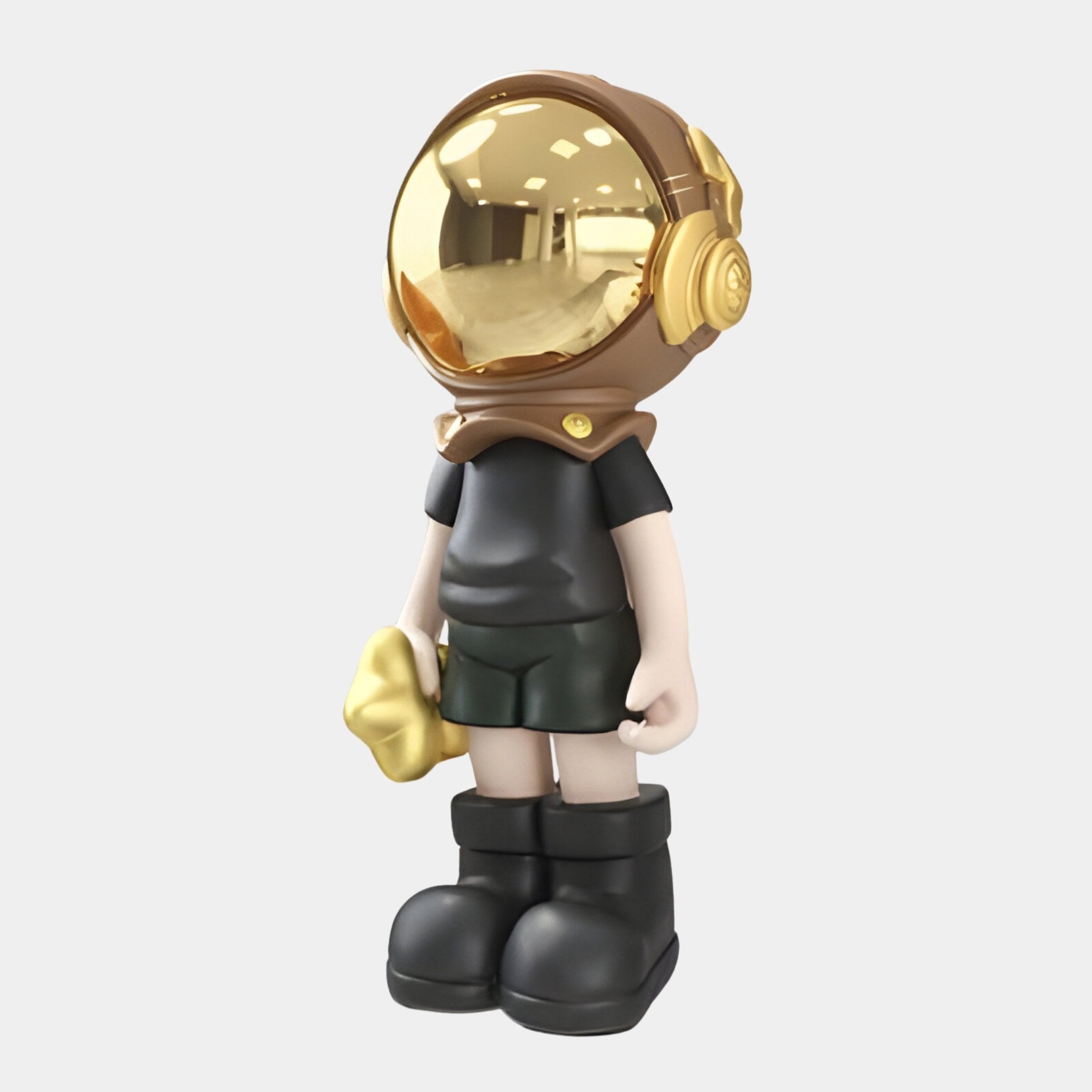 The Midnight Black Astronaut Buddy Sculpture by Giant Sculptures features a shiny gold helmet with headphones, sleek black attire, and stands holding a gold cloud-shaped object. This 70cm space-themed décor piece contrasts against a plain white background, reflecting its surroundings.