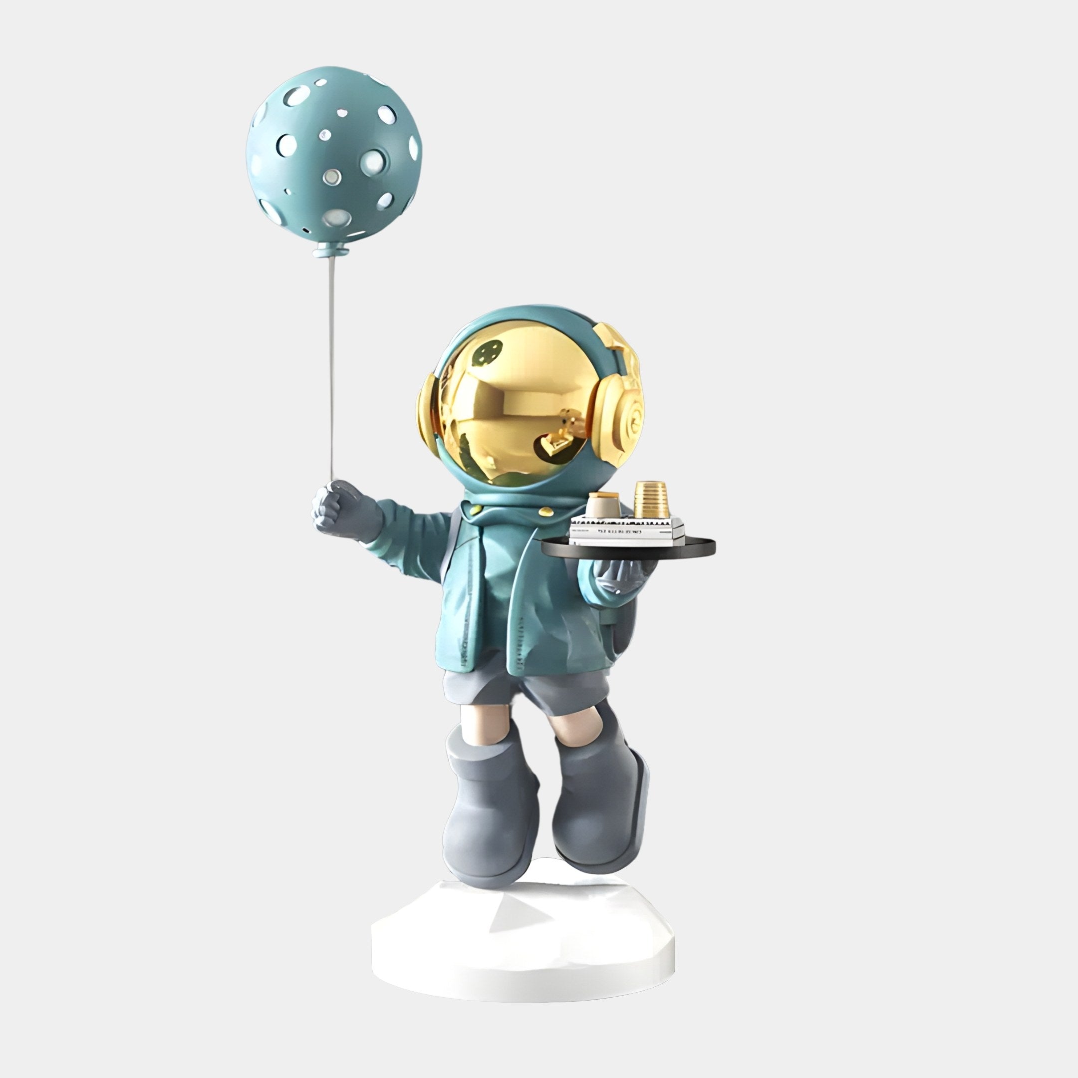 The 80cm Galactic Blue Astronaut Butler Balloon Sculpture by Giant Sculptures features a whimsical figurine with a gold helmet, holding cups on a tray and a dotted teal balloon, dressed in a teal hoodie and grey boots, all standing on a white base.