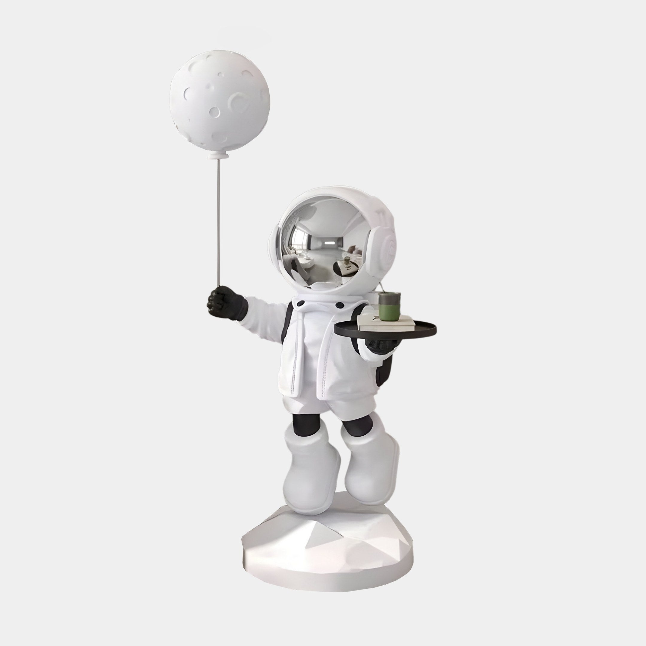 The 80cm Nova White Astronaut Butler Balloon Sculpture by Giant Sculptures features a small astronaut on a faceted base, with a moon-shaped balloon in one hand and a candle tray in the other. Its reflective helmet adds cosmic flair to the space and exploration theme.