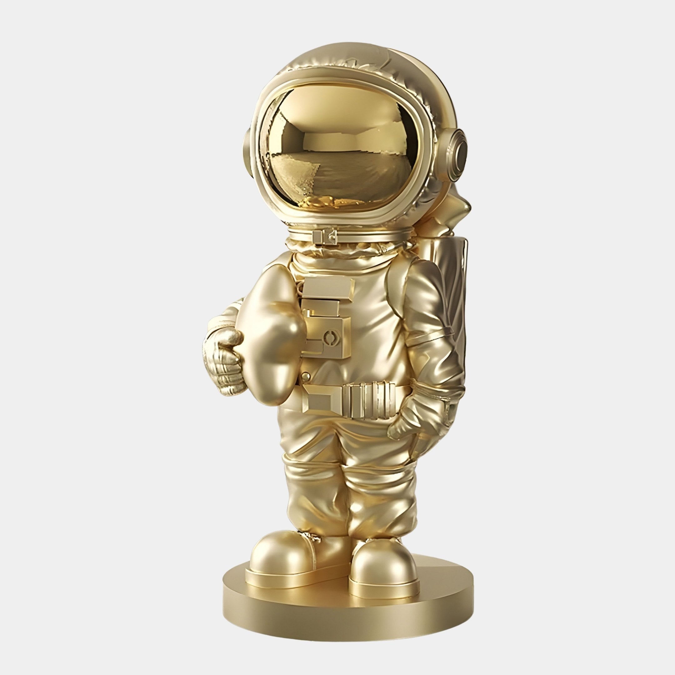 The Giant Sculptures Celestial Gold Astronaut Star Sculpture (85cm) features a figurine in a traditional spacesuit with a reflective visor, standing on a circular base and holding a helmet. Its sleek, metallic luster embodies the spirit of space exploration.