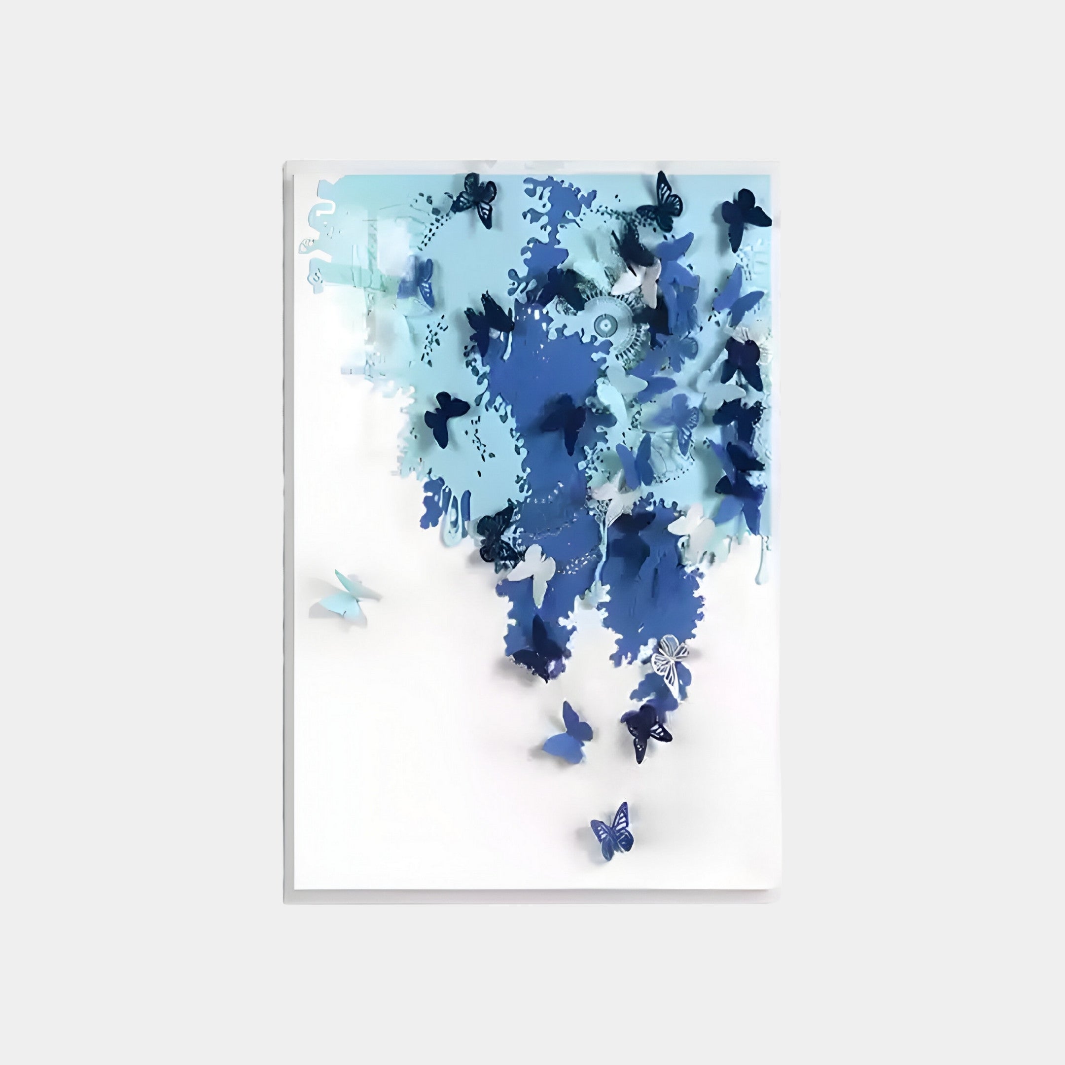 The Luminara Blue II Butterfly Paper 3D Wall Art by Giant Sculptures showcases handcrafted elegance with blue butterflies on a white canvas, cascading down to create a sense of movement and depth.