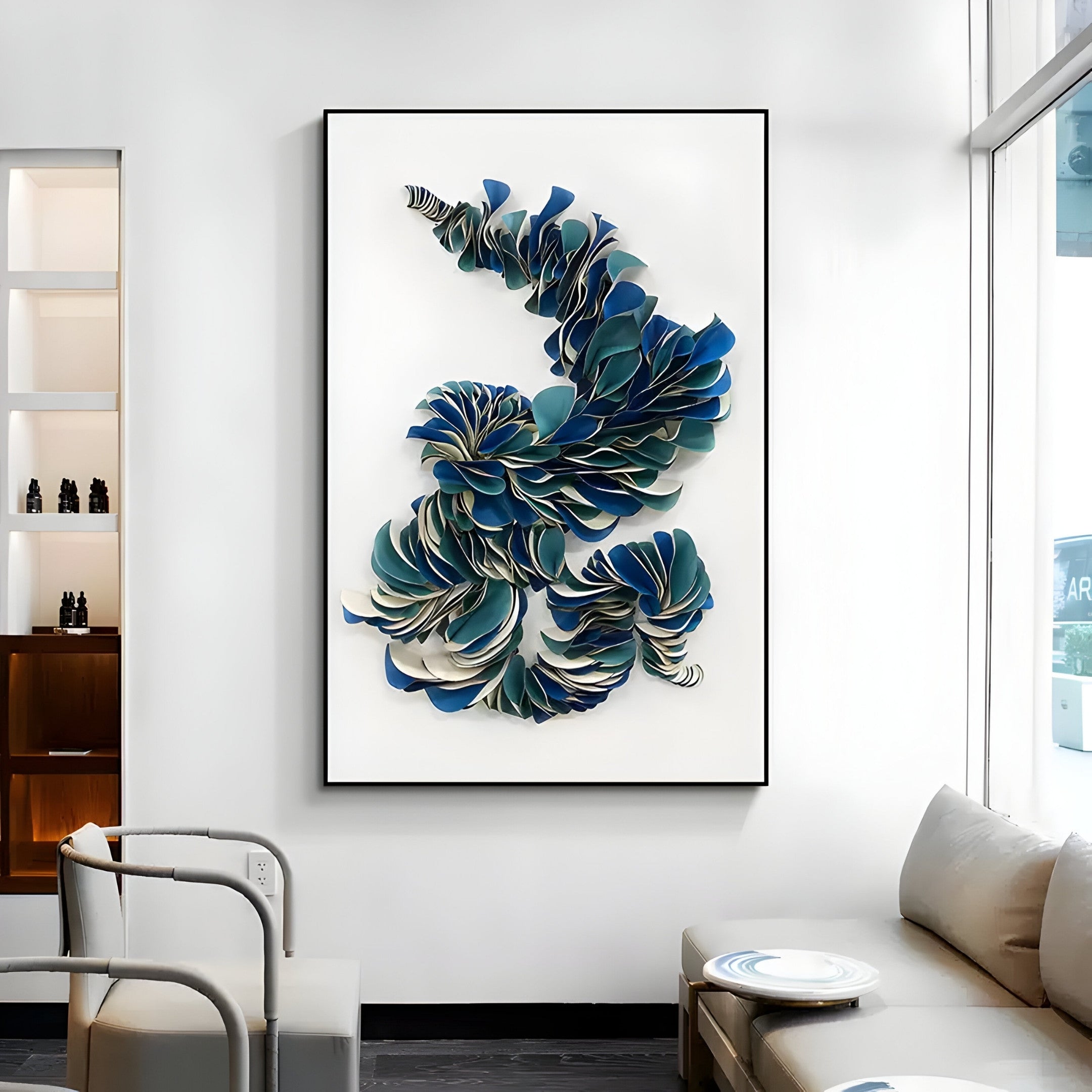 A modern living room highlights a stunning piece from Giant Sculptures, the Aeriform Blue Whirl Leather Abstract Wall Art. It features a white couch, a side table, and floor-to-ceiling windows that flood the space with natural light.