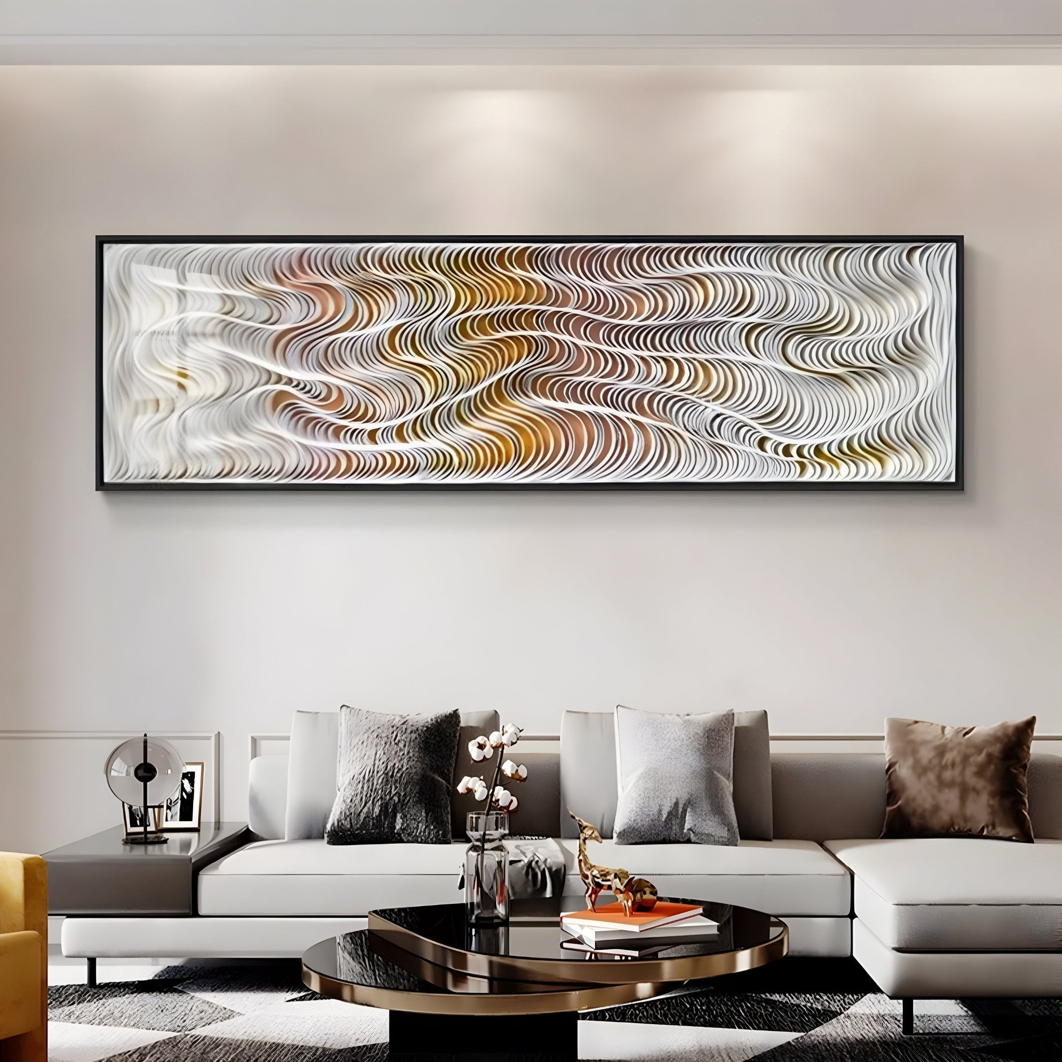 A modern living room features the Fluenta Sunlit Ripple Linear Cardboard 3D Wall Art by Giant Sculptures with warm wavy patterns in an aluminum frame. A light gray sofa with cushions, a decorative coffee table, and ambient lighting enhance the cozy atmosphere.