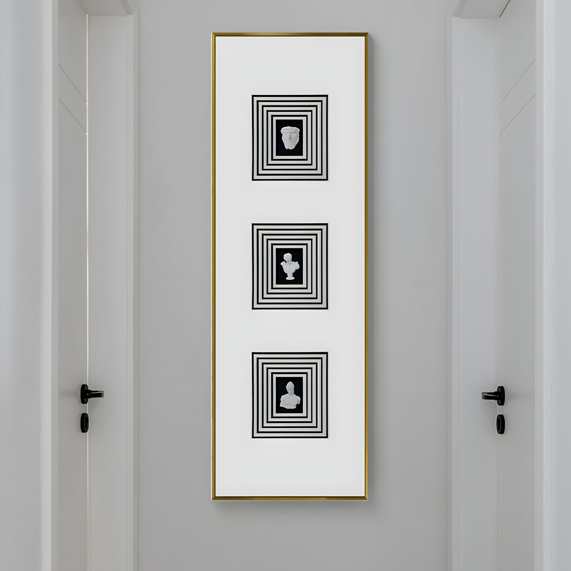 A narrow, white hallway features the Lustre Black & White Plaster Statue Vertical Wall Art by Giant Sculptures, a French-inspired centerpiece with three concentric black squares each encircling a silhouette. Black door handles are visible on doors to the left and right.