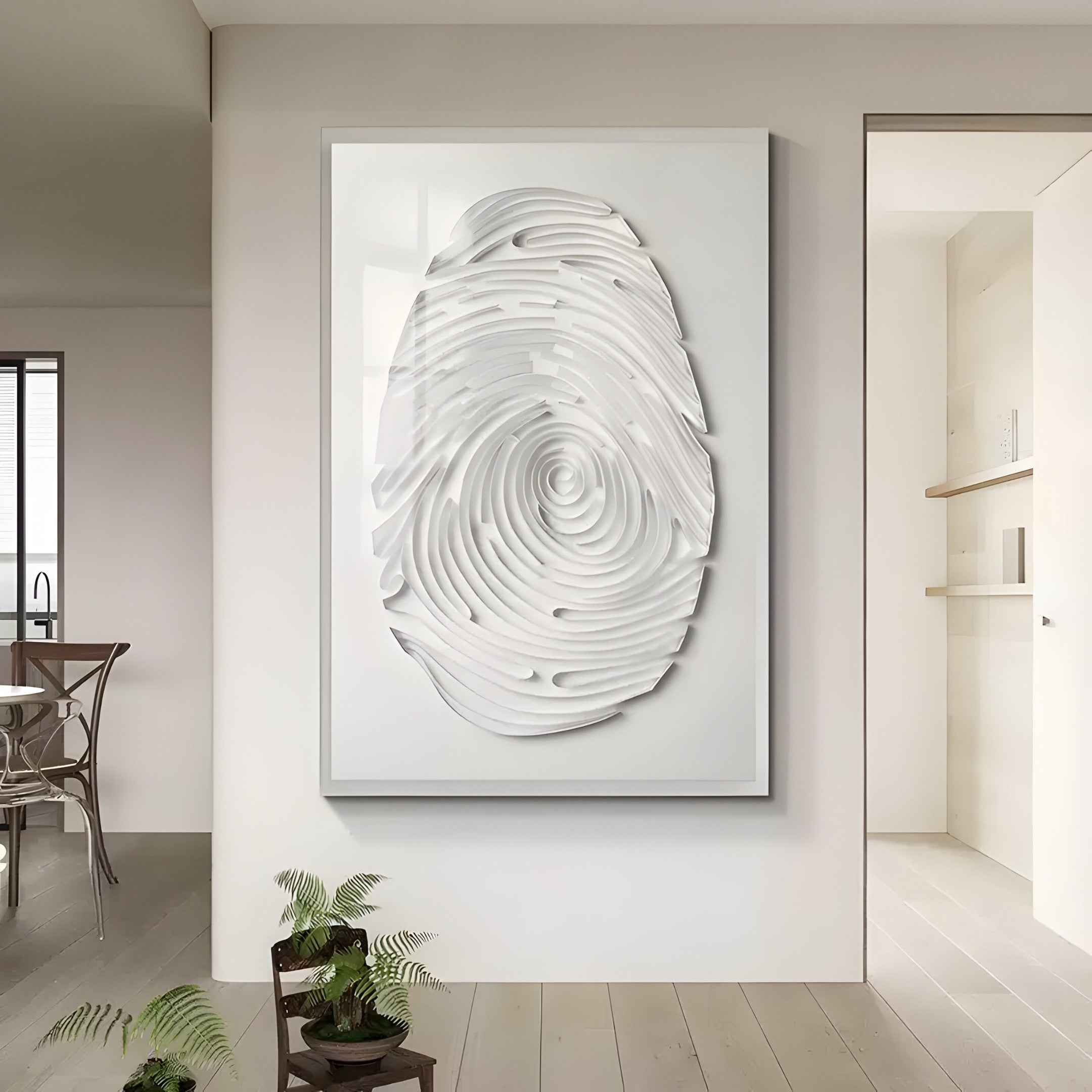 In a modern, minimalist room, the Giant Sculptures Imprint White Fingerprint Personalised Abstract Wall Art hangs prominently. A small plant adorns the corner floor, while a dining table with chairs peeks into view from the background.