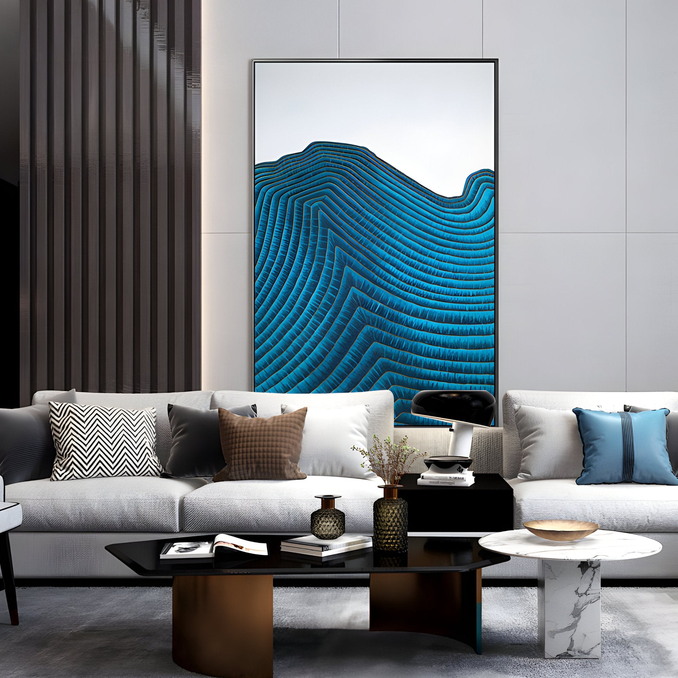 A modern living room features a white couch with blue cushions. Ripplewave II Abstract Blue Decorative Enamel Wall Art by Giant Sculptures, illustrating wave-like patterns, graces the wall. A stylish coffee table with decorative items and a patterned rug complete the luxurious decor.