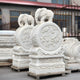 The customized "Elephant On Drum Marble Outdoor Sculpture" by Giant Sculptures features two intricately hand-carved marble figures of elephants atop circular designs with floral motifs. These elegant sculptures, displayed near a building in an outdoor setting, are set on ornate bases and highlight their exquisite craftsmanship.