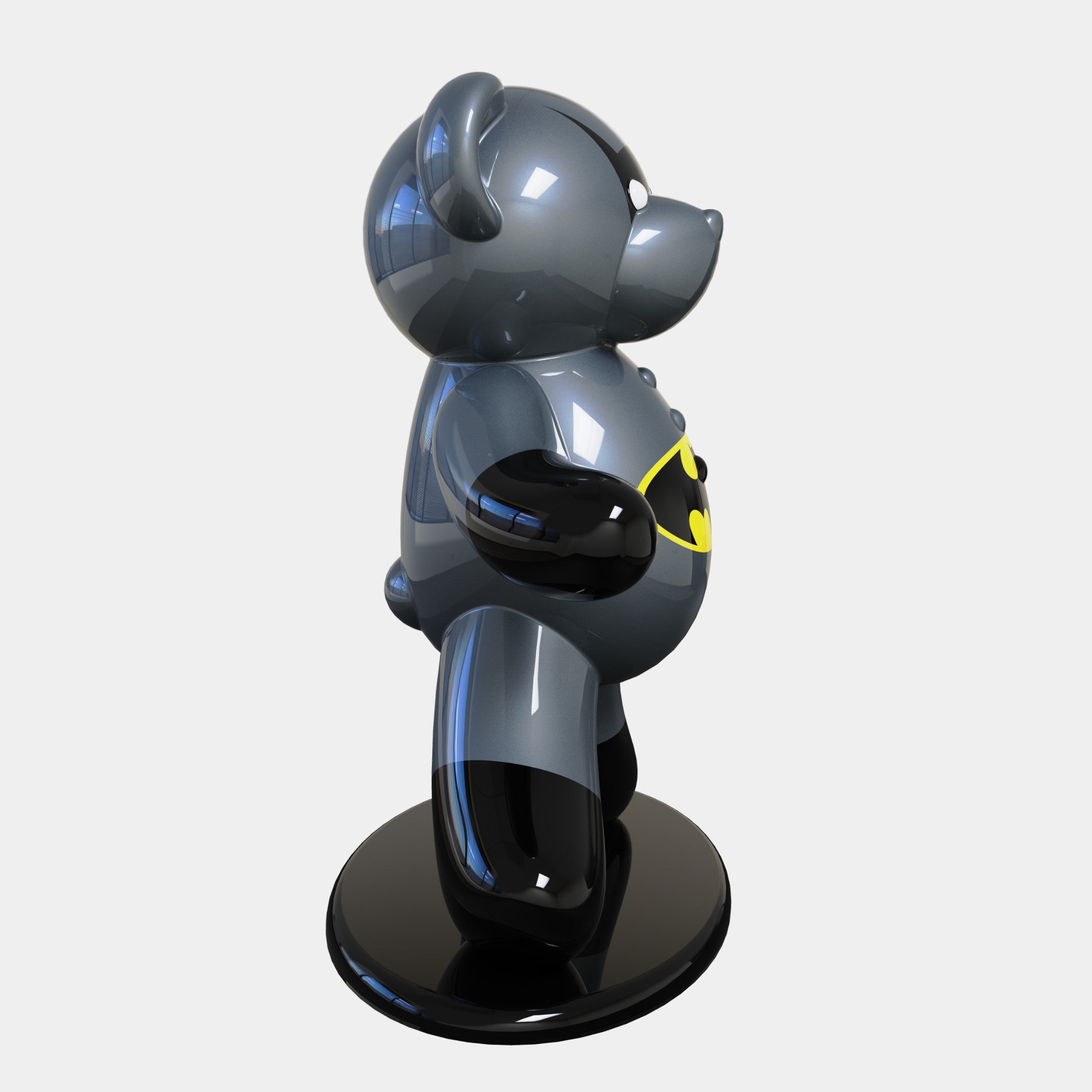 The Gacko Batman Bear Sculpture by Giant Sculptures is a 165cm, glossy, bear-shaped figure on a round black base. It features a shiny dark gray finish with a bat-like logo on its chest and showcases playful, cartoonish style while facing left. This is a limited-edition piece.