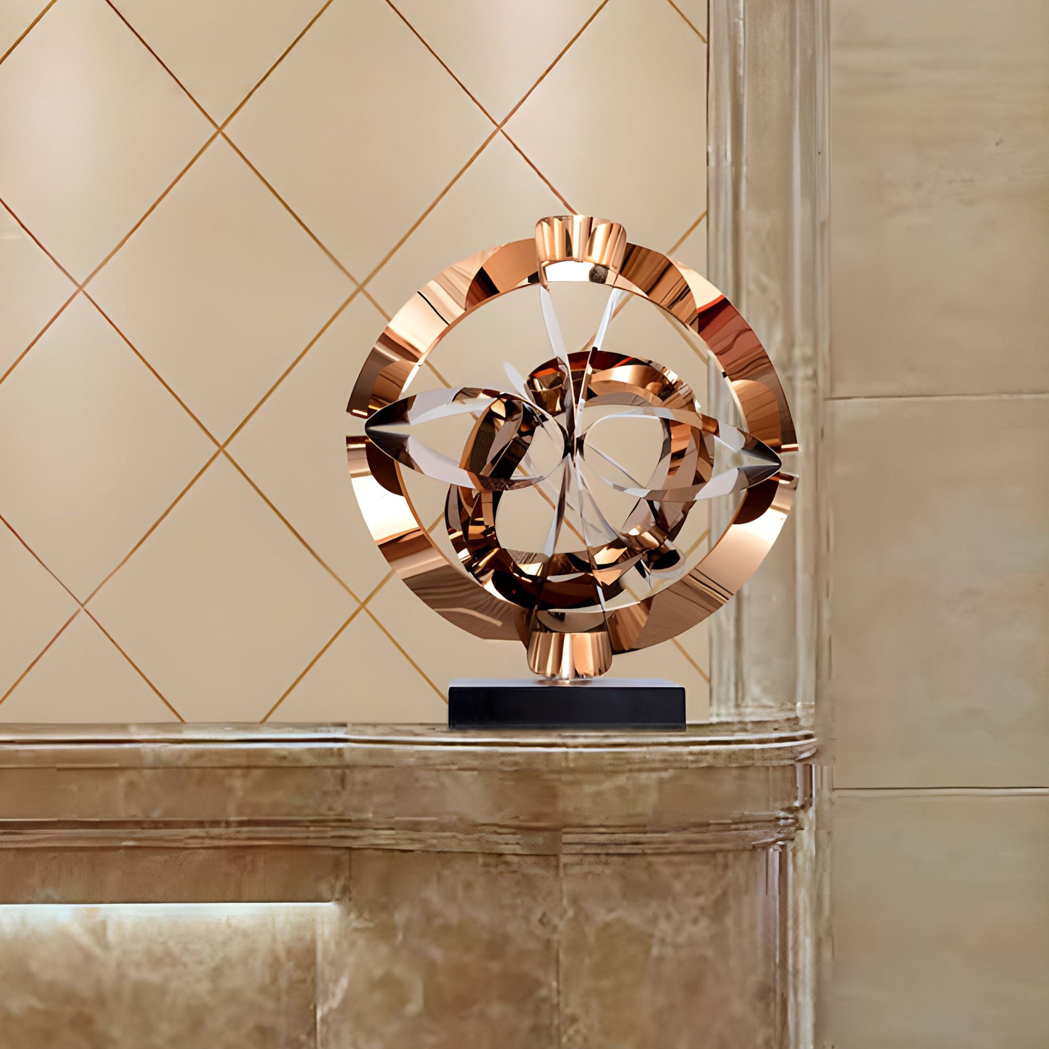 The Orbit Copper Geometric Steel Sculpture by Giant Sculptures, featuring interlocking curved forms crafted from stainless steel rings, is displayed on a marble surface against a striking geometric beige wall.