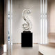 Tall silver mosaic swirling sculpture placed in an elegant home interior with modern décor.