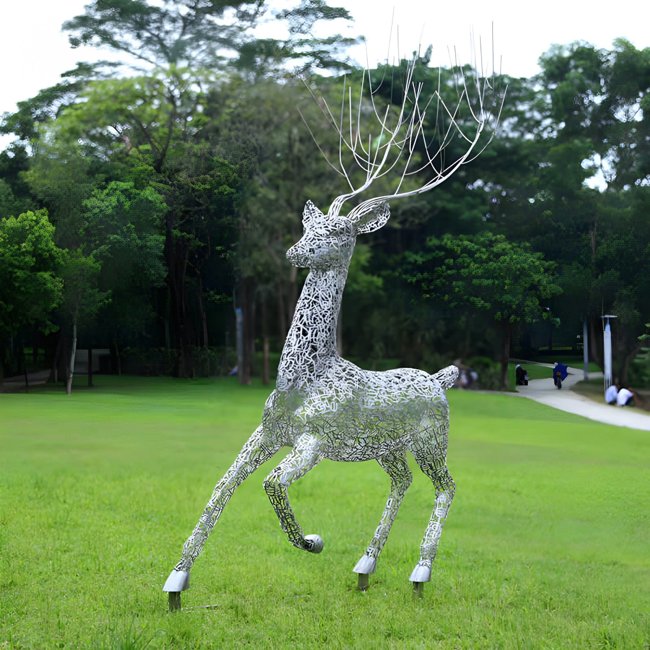 Elegant deer sculpture with tree-like antlers in a grassy outdoor setting, highlighting contemporary outdoor art and nature-inspired design.