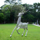 Elegant deer sculpture with tree-like antlers in a grassy outdoor setting, highlighting contemporary outdoor art and nature-inspired design.