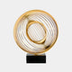 Circular sculpture in a gold finish with concentric, spiraling rings on a black base.