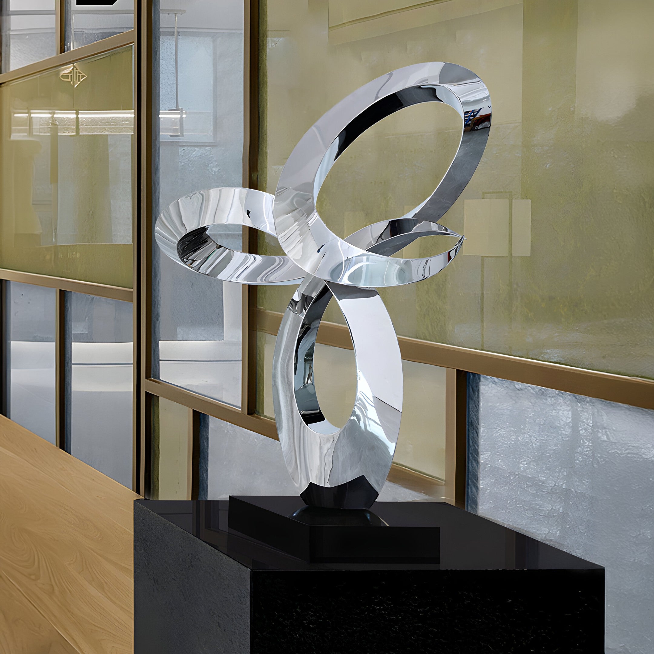 Infinity Loop stainless steel sculpture displayed in a modern indoor space, reflecting light and enhancing its sleek, artistic form.