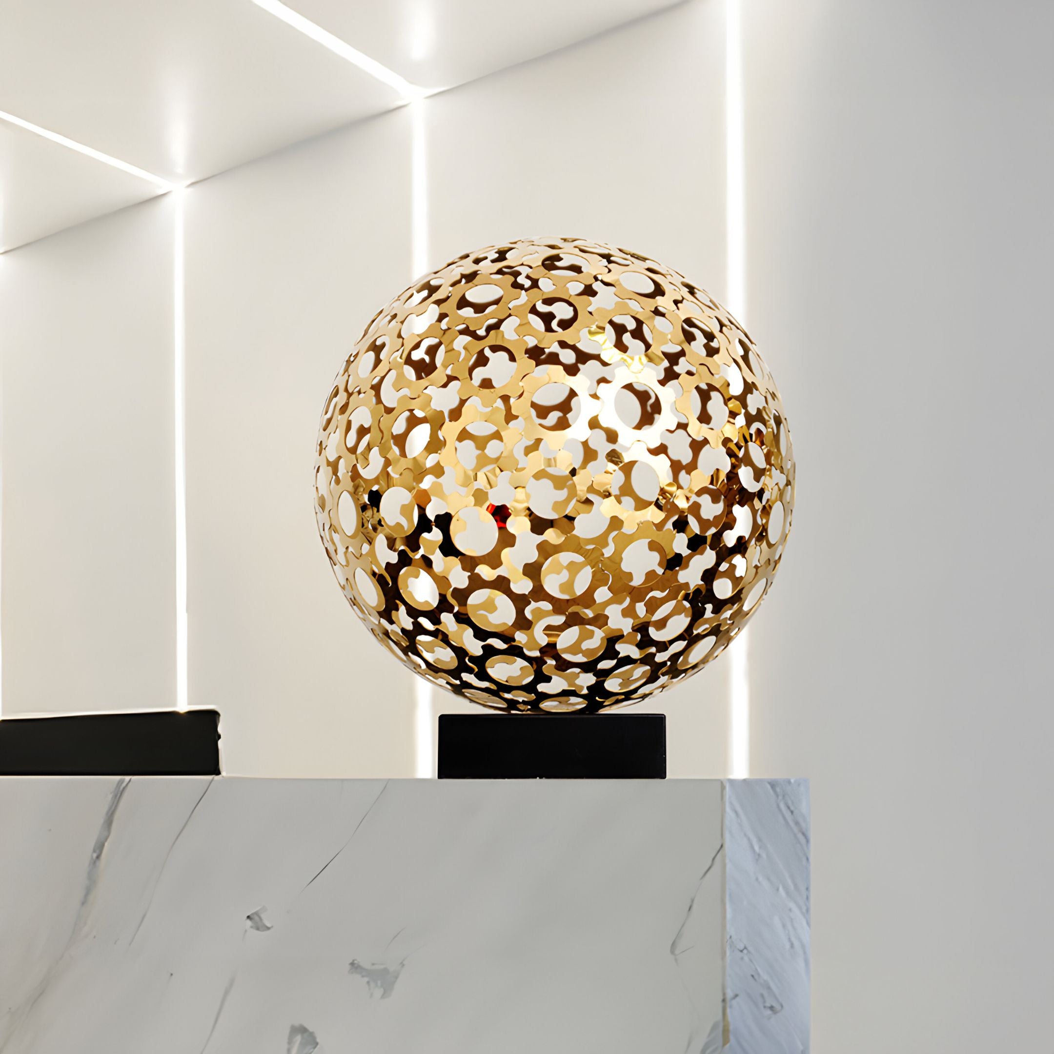 The Eclipse Gold Sculpture featured in a minimalist interior setting, highlighting its luxurious gold finish and eye-catching circular pattern design.