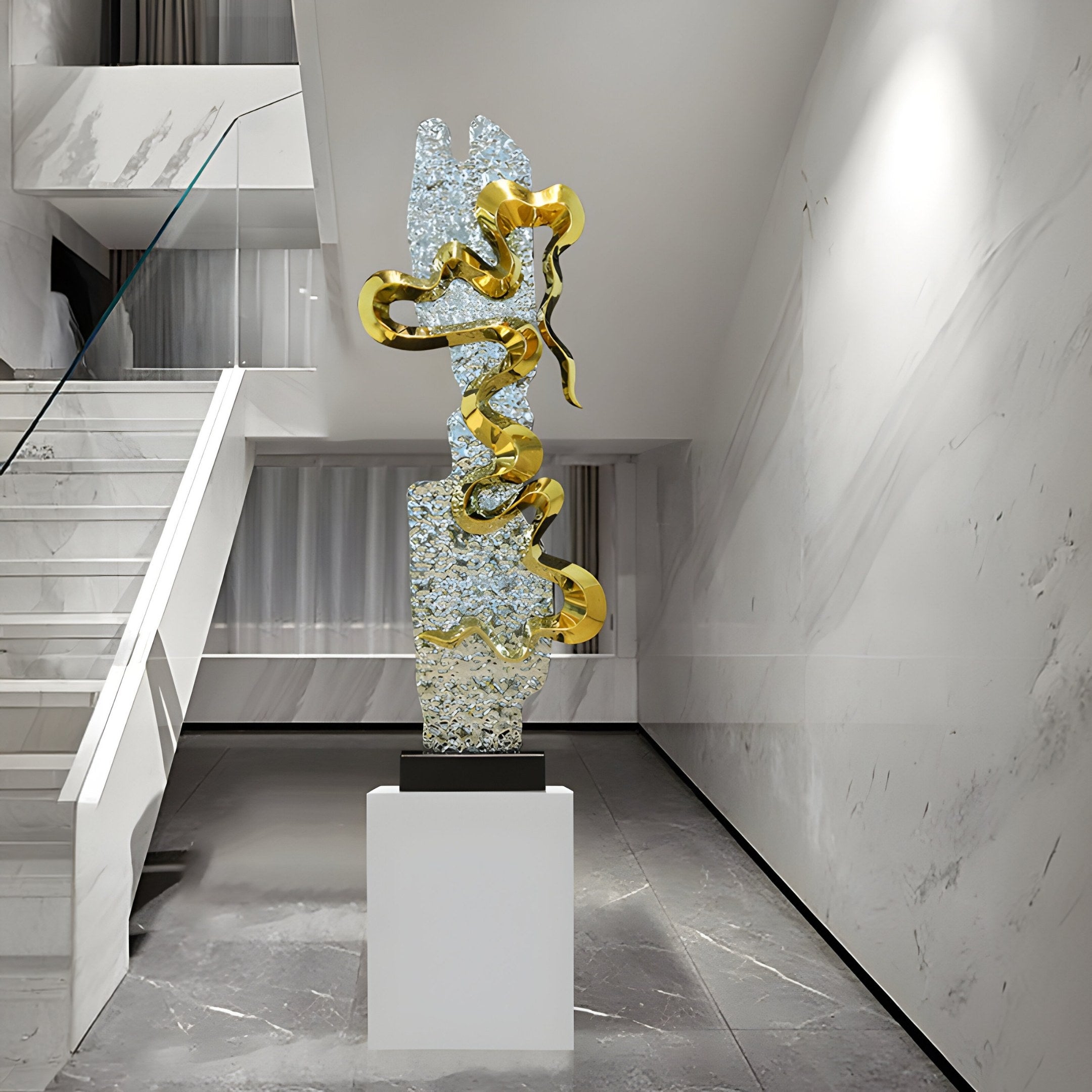 The Harmony Organic Steel Sculpture - 120cm by Giant Sculptures features gold-accented twisting ribbons on a textured, reflective stainless steel surface. It stands on a white pedestal in a minimalist room with marble floors and an organic design staircase to the left.