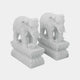 The Indian Elephant Marble Outdoor Sculpture - Customised by Giant Sculptures features two hand-carved elephant statues made of marble, standing on ornate rectangular bases. These magnificent sculptures boast intricate details, gracefully and majestically displayed against a plain backdrop.