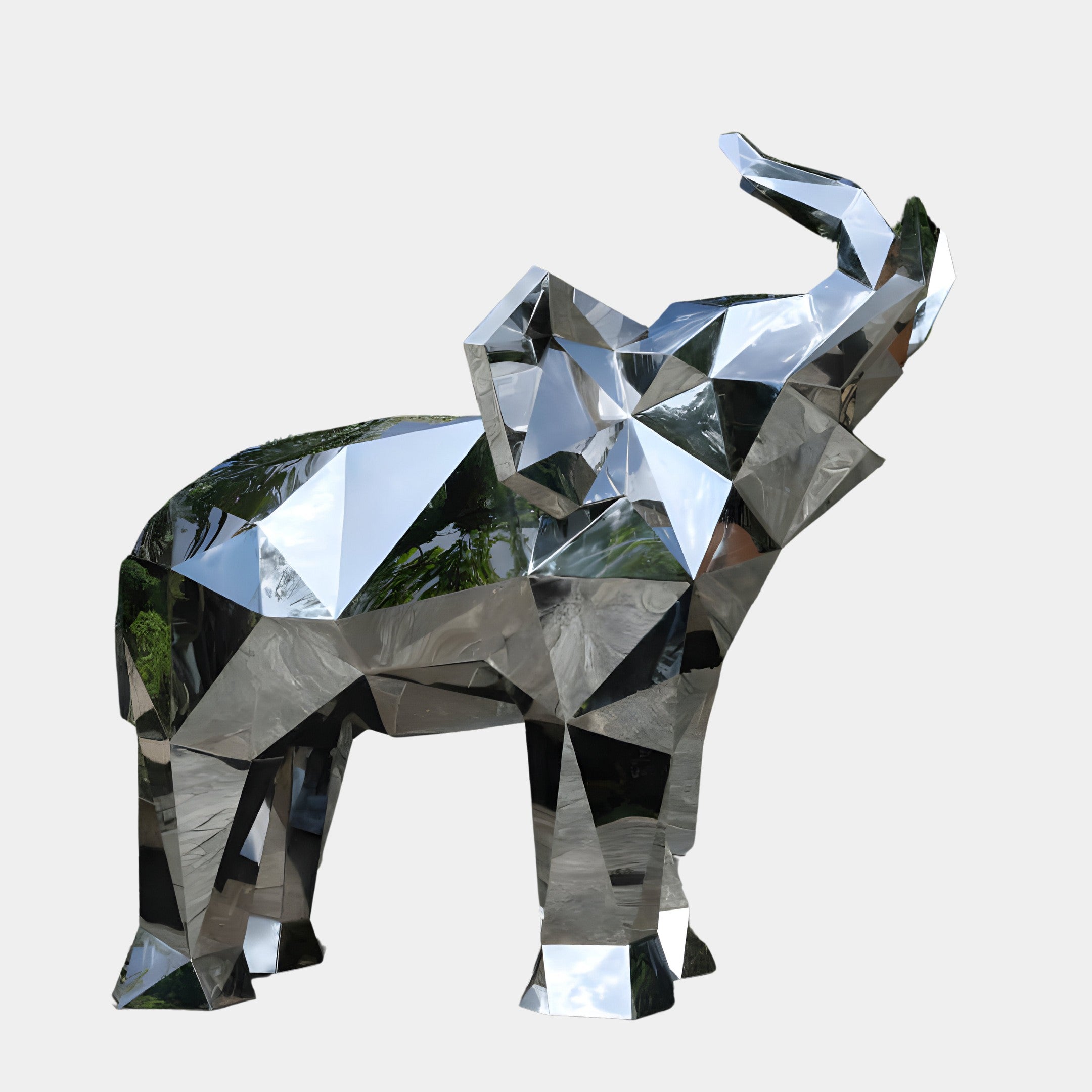 A geometric, faceted silver elephant sculpture standing tall with its trunk raised.