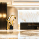 Golden abstract sculpture, placed prominently in a spacious lobby, beside a luxurious reception area.