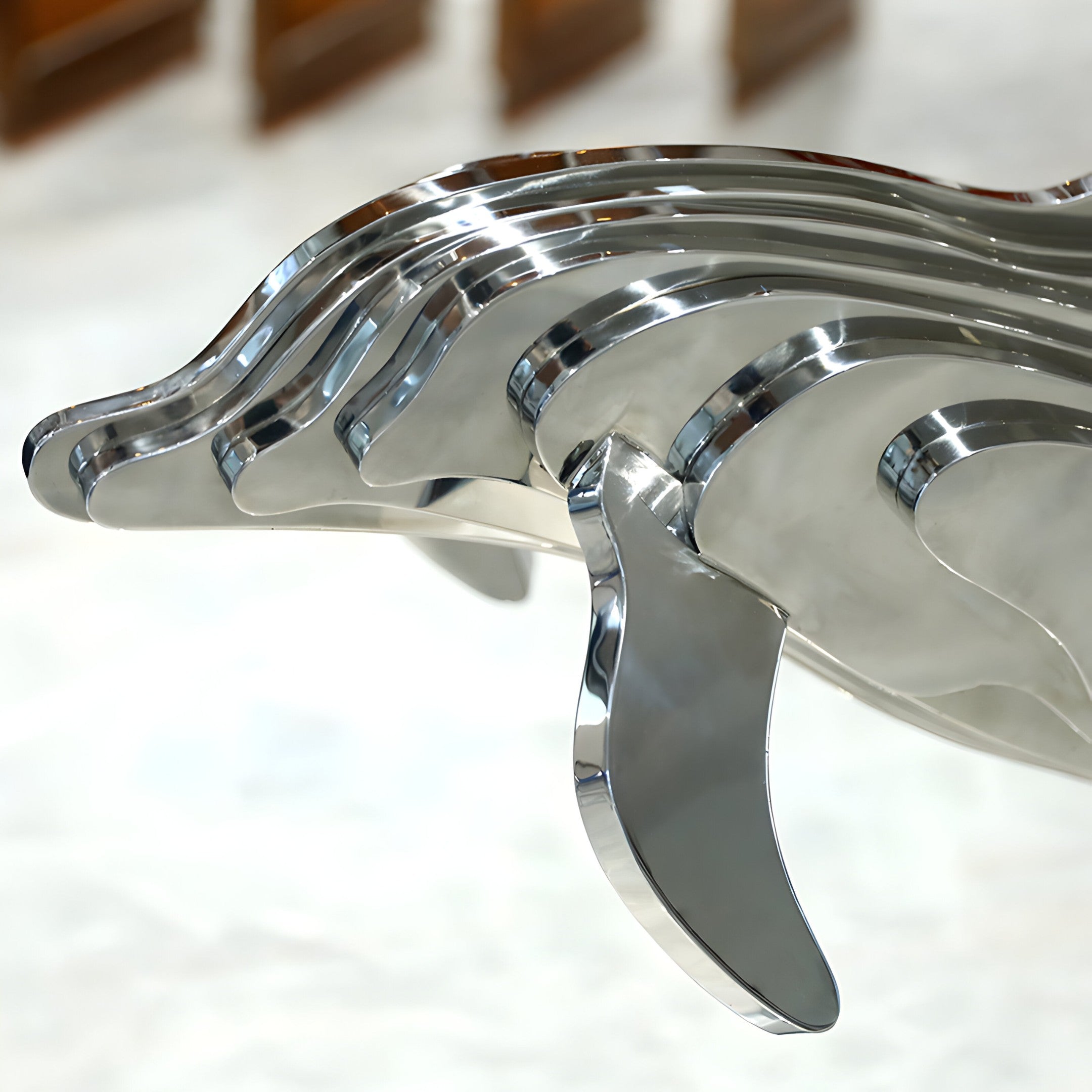 Elegant silver-toned close up of a dolphin sculpture crafted from stainless steel, designed as a modern focal point for gardens or upscale courtyards.