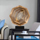 Bronze hexagonal sculpture styled in a contemporary living room with a coffee table and soft furnishings.