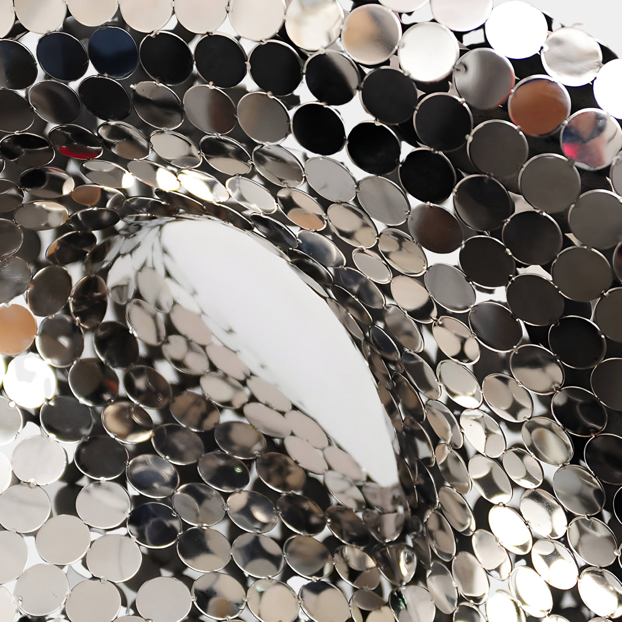 Close-up of the abstract sculpture showing a detailed view of the reflective, mirrored surfaces.