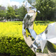 A wide view of the camel sculpture, set against a lush green landscape, reflecting its surroundings.