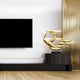 A modern living room features a large, wall-mounted TV and the Breeze Gold Organic Abstract Steel Sculpture by Giant Sculptures on a pedestal. The wooden floor and vertical golden slats enhance its contemporary art appeal.