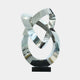 A silver abstract ring sculpture made from intertwined loops, placed on a black base.