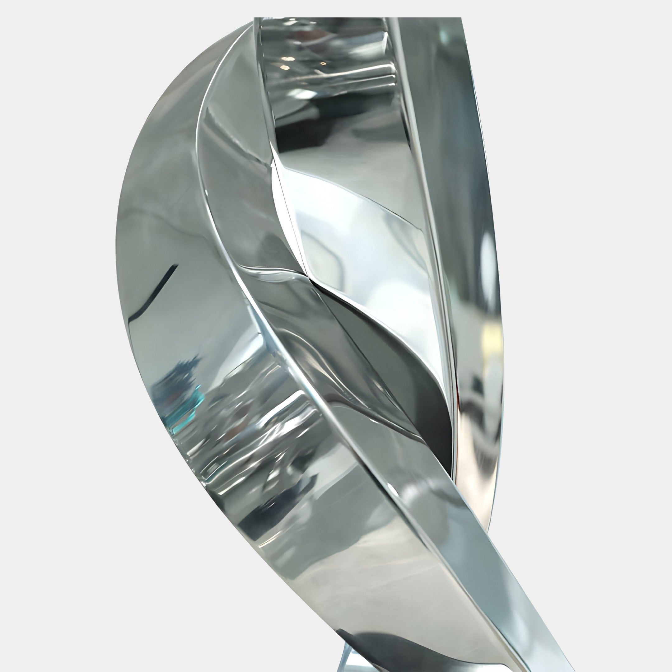 A close-up shot of the silver sculpture, highlighting the smooth curves and reflective metallic surface.