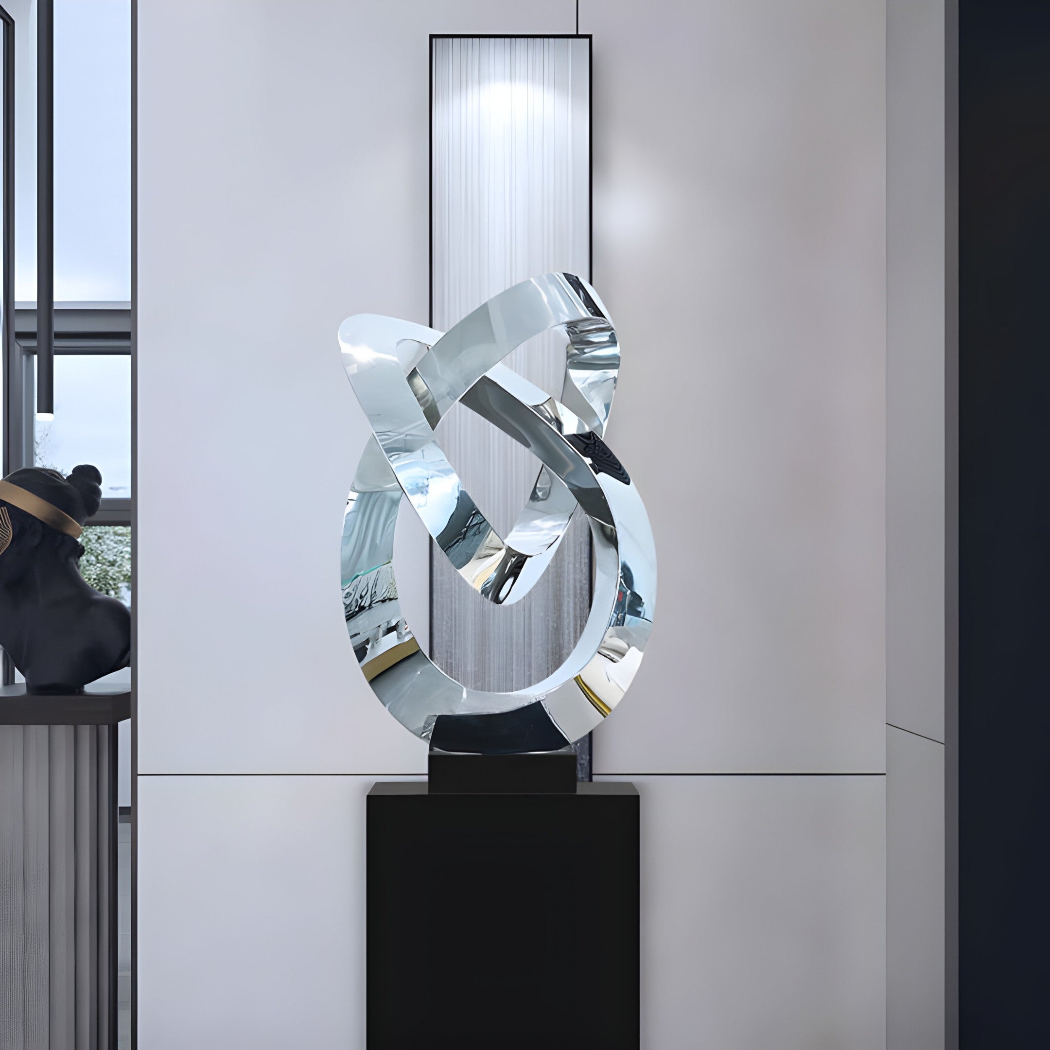 The silver sculpture displayed in a minimalist interior space, with reflections of the room's surroundings.