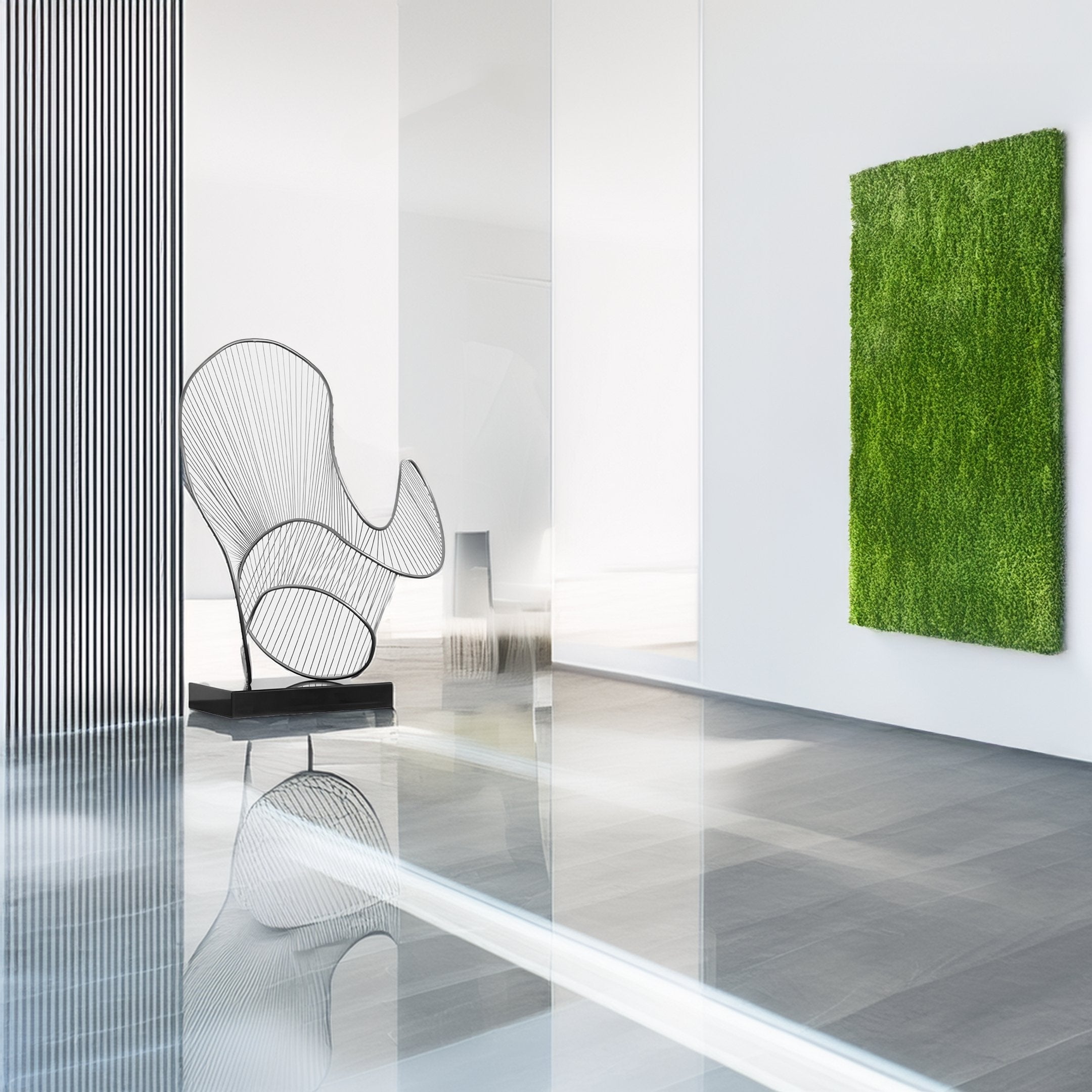 In a modern, minimalist room with glossy floors and sleek white walls featuring vertical stripes, a large wire abstract chair takes center stage. To the right, vibrant green grass-like wall art enhances the Giant Sculptures Cheri Silver Abstract Steel Sculpture - 72cm.