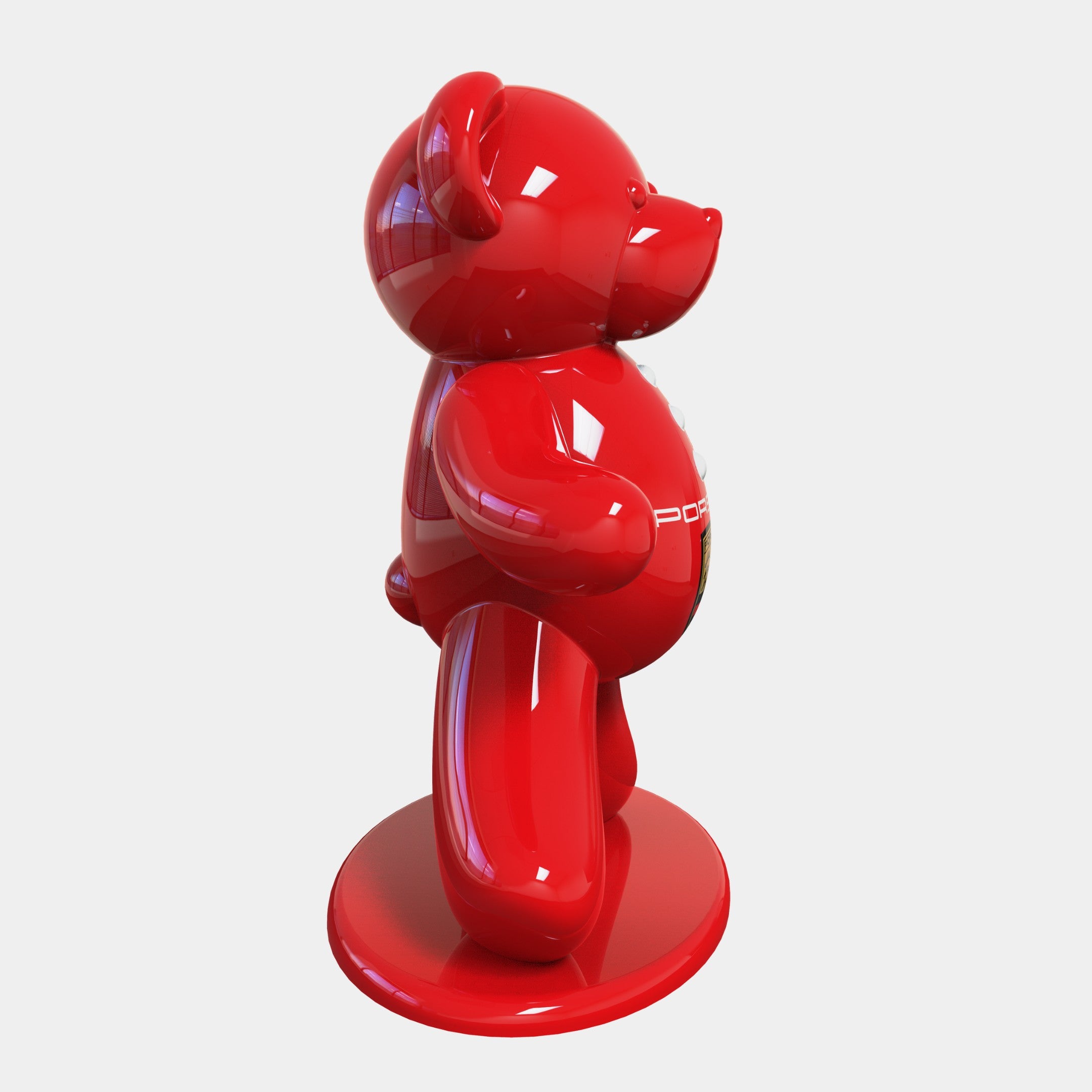 Standing at 165cm, the Gacko Porsche Bear Sculpture by Giant Sculptures features a shiny, red, abstract bear on a matching round base with a glossy finish. This Pop Art-inspired piece blends automotive design with artistic expression against a white backdrop.