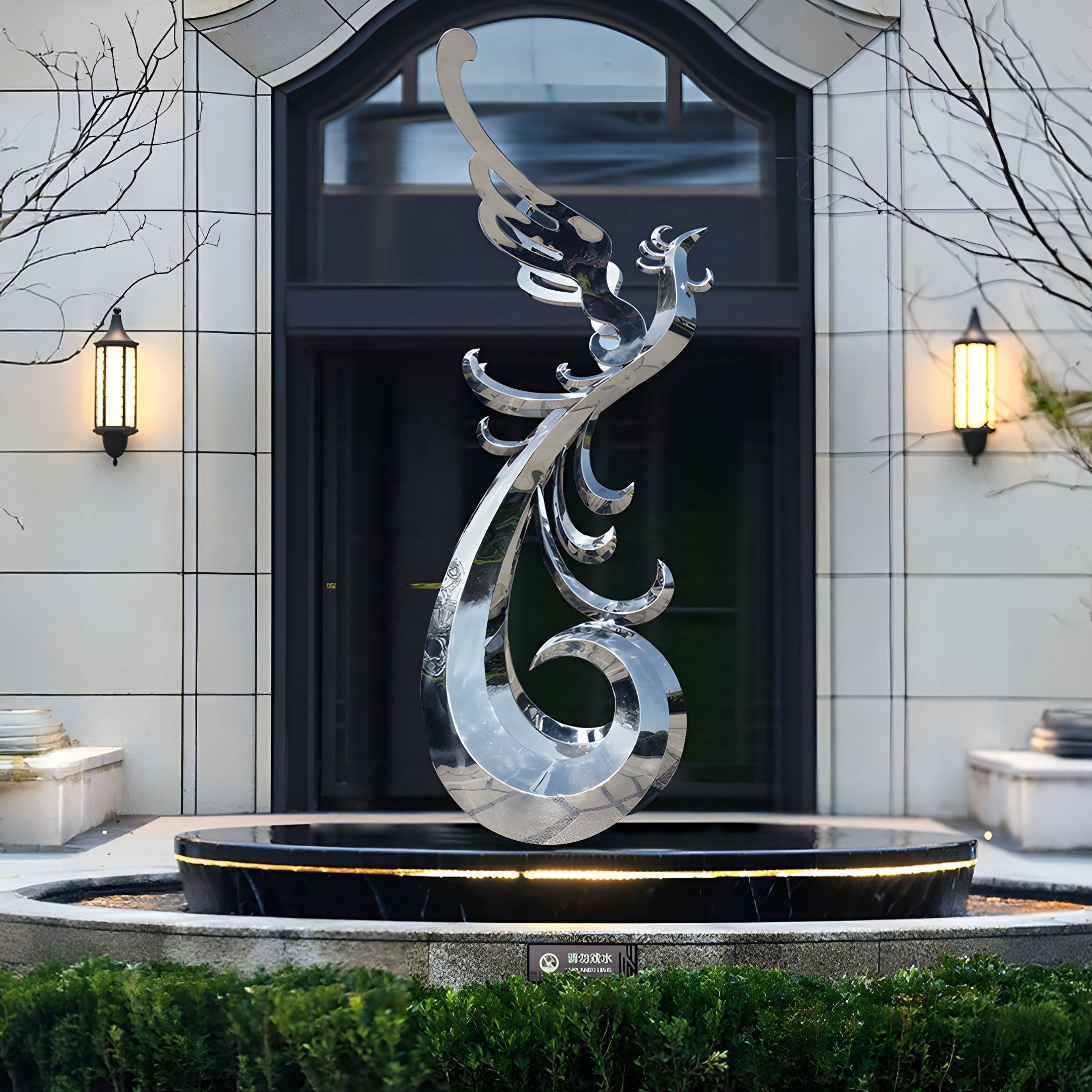 The 212cm Phoenix Silver Abstract Outdoor Steel Sculpture from Giant Sculptures stands gracefully at the building entrance on a pedestal, framed by bushes and bare branches. A large window and two wall-mounted lanterns provide a stunning backdrop to this contemporary masterpiece.