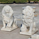 Giant Sculptures Giant Lion With Cub Marble Outdoor Sculpture - 120cm features two white marble lions on concrete, epitomizing luxury garden art. The left lion displays an open mouth with a cub between its paws; the right rests on a sphere. They showcase detailed manes and alert postures against lush grass.