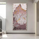 The Artevo 3D Ceramic Wall Art by Giant Sculptures, showcasing plum and amber tones with rows of elongated shapes, adds a serene abstract landscape vibe to a modern minimalist room featuring light-colored walls and floors.