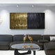 A modern living room features a black sectional sofa, a glass-topped coffee table with two golden crane sculptures, Ripple Dual-Tone Black & Gold Textured Wall Art by Giant Sculptures, and textured stainless steel ceiling spotlights.