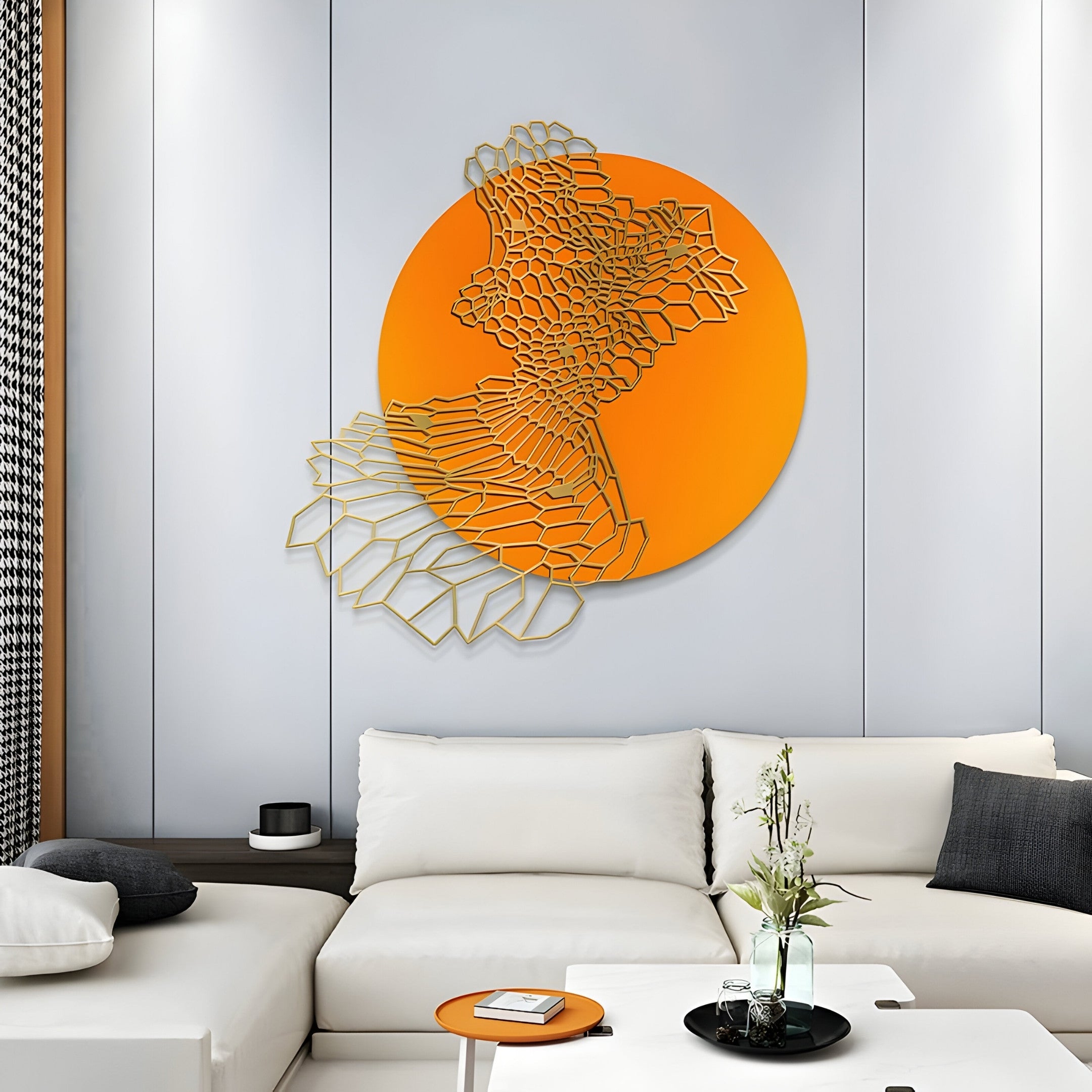 A modern living room exudes contemporary elegance with a white sectional sofa accented by monochrome throw pillows. The wall features the Cellura Orange Geometric Layered Gold Wired Metal Wall Art by Giant Sculptures, and a small orange table adorned with decorative items completes the stylish ensemble.