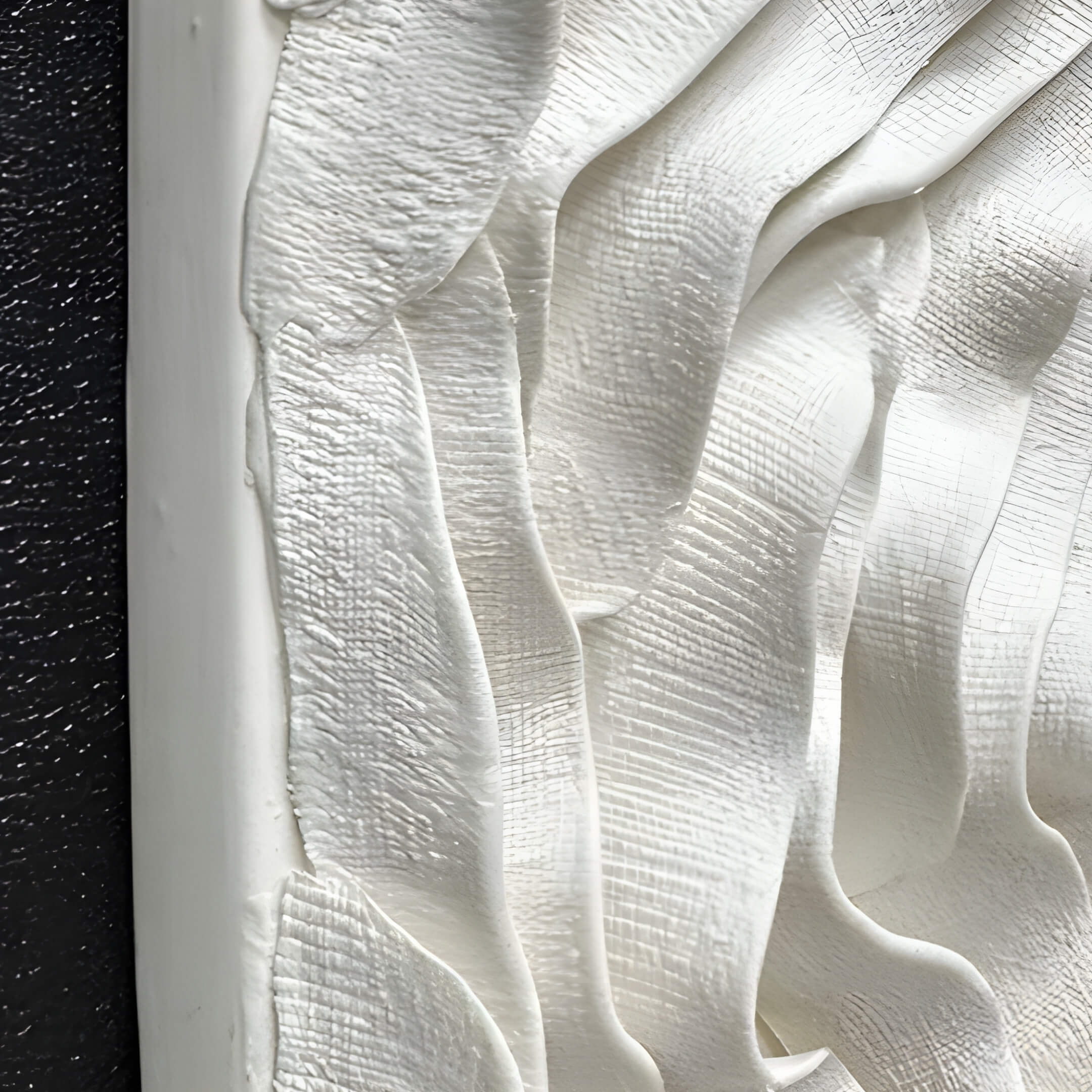 Close-up of textured white ceramic waves showcasing intricate hand-crafted details and flowing lines, highlighting the sculpture's organic aesthetic.