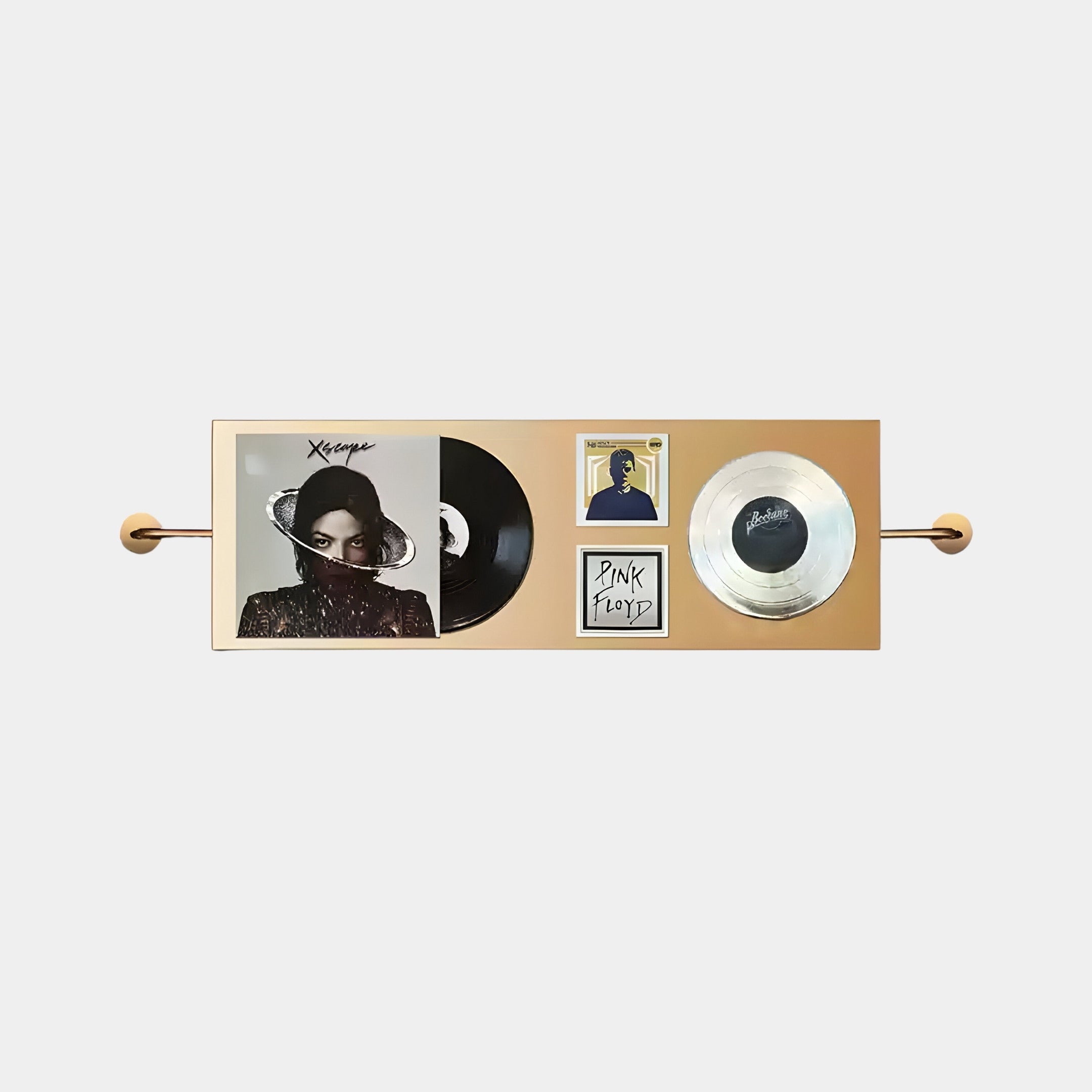 The Resonance Record Wall Art by Giant Sculptures showcases a Michael Jackson vinyl record, album cover with a person partly obscured by a black scarf, and two memorabilia pieces, featuring a silver disc and discreet Pink Floyd nods, all elegantly set against a beige background.