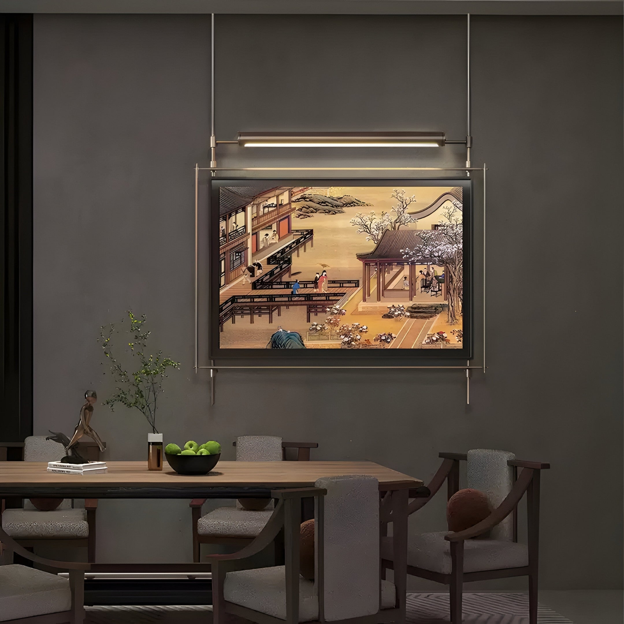 A dining room features a wooden table with chairs, a bowl of green apples, and a small vase with flowers. The Celestique Vintage Pavilion Bliss Framed LED Wall Art by Giant Sculptures illuminates an outdoor scene with architecture and figures, blending modern aesthetics into the vintage ambiance.