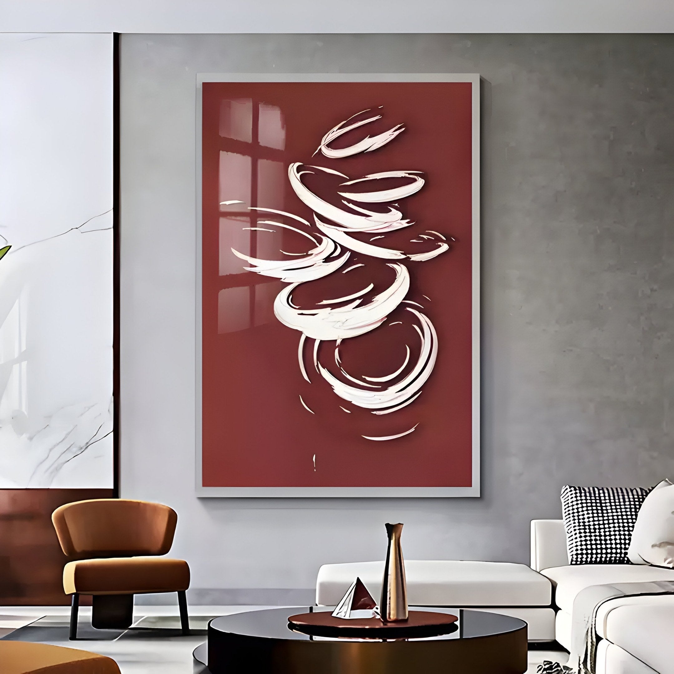 A sleek living room highlights Giant Sculptures’ Zephyr Crimson Swirl Abstract Metal Wall Art, featuring white lines on maroon. It includes a white sofa, brown chair, round coffee table with a vase, and a decorative wall, embodying modern artistry.