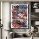 The Scriptura I Multicolour Graffiti Expression Metal Wall Art by Giant Sculptures showcases vibrant blue, red, and black graffiti-style lettering. Its displayed in a modern room with neutral tones, accompanied by a minimalist shelf, couch, and decorations like a vase with pampas grass.